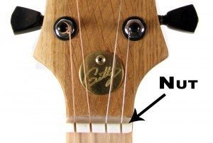 This photo shows an example of a standard bone nut in use on a four-string cigar box guitar.